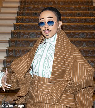 Quirky: In the mood for haute couture, the singer, 27, made a bold statement again when she arrived at the Viktor & Rolf show with glued-on eyebrows, a mustache and a goatee - a far cry from her usual look (R)