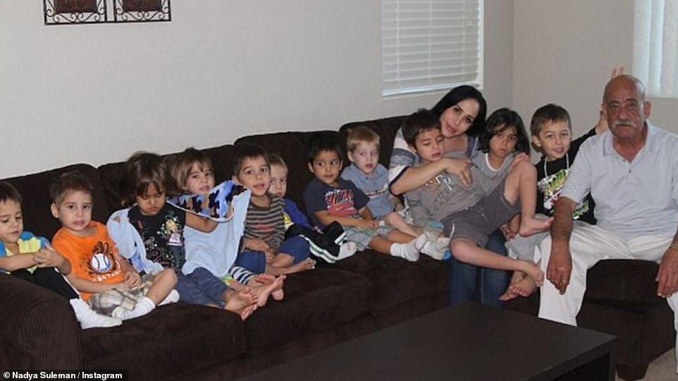 Her mini kids: The star is seen here about a decade ago as she poses at home with 11 of her 14 children