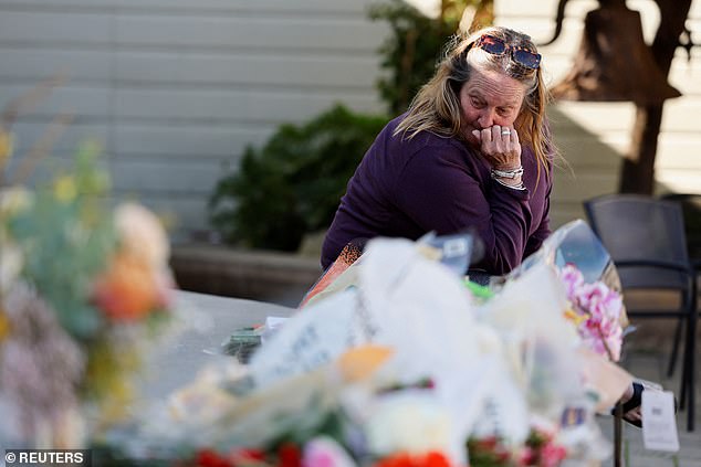 Elisabeth Olander, 68, a Half Moon Bay resident, weeps at the memorial for the victims of the massacre.