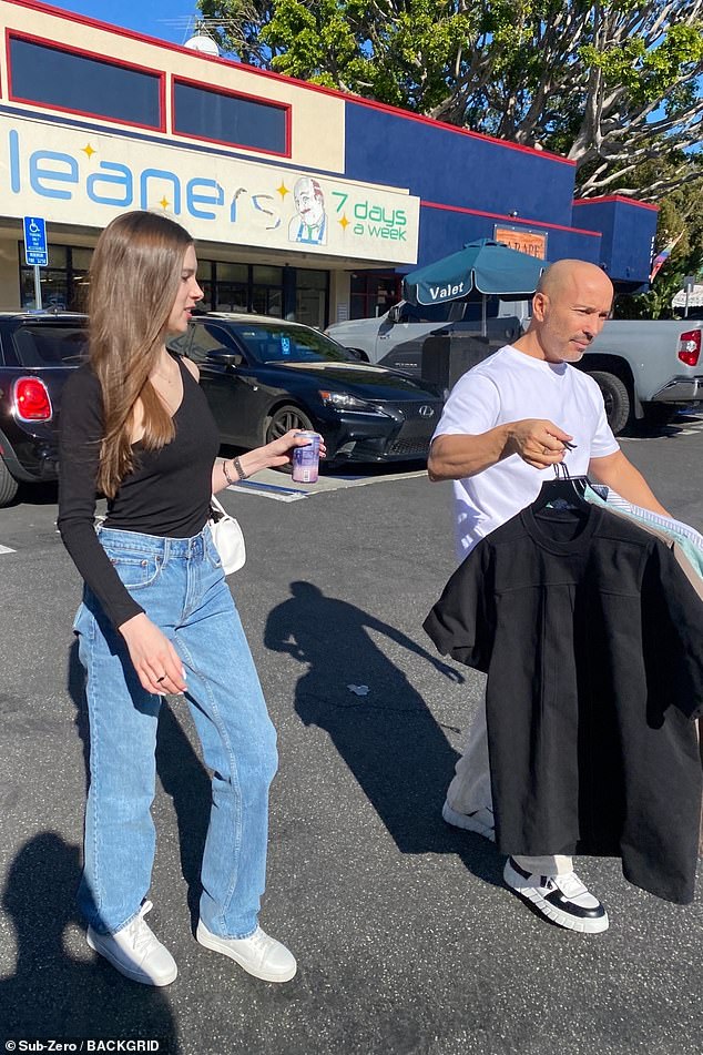 Casual cool: The realtor, 45, carried his clean designer Balenciaga T-shirts in hand, while his stunning partner walked nearby.