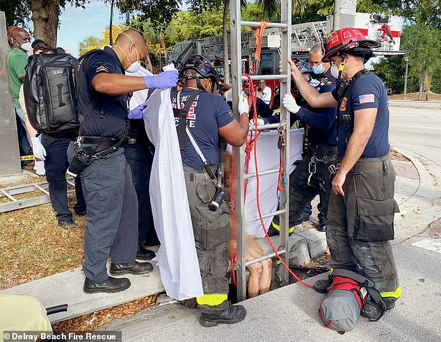 Firefighters are seen pulling Kennedy from the eight-foot-deep drain under a sidewalk in Delray Beach in March 2021 after a pedestrian heard cries for help.