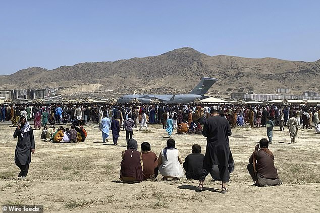 Hundreds of people gather near a US Air Force C-17 transport plane on the perimeter of Kabul International Airport, Afghanistan, in August 2021 during the US withdrawal.