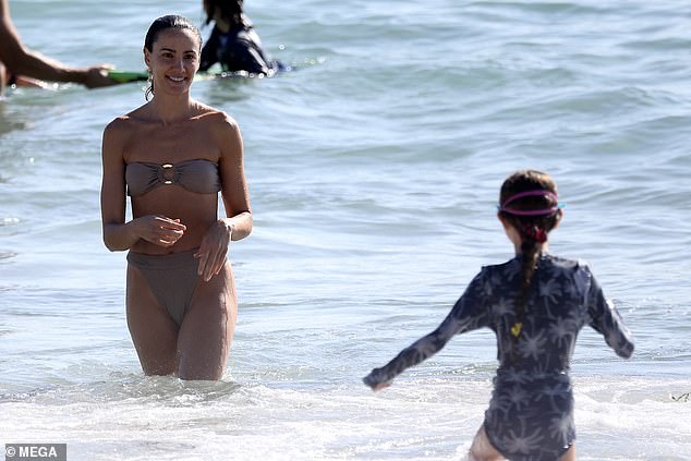 The brunette gazed adoringly at her daughter Violet in the waves.