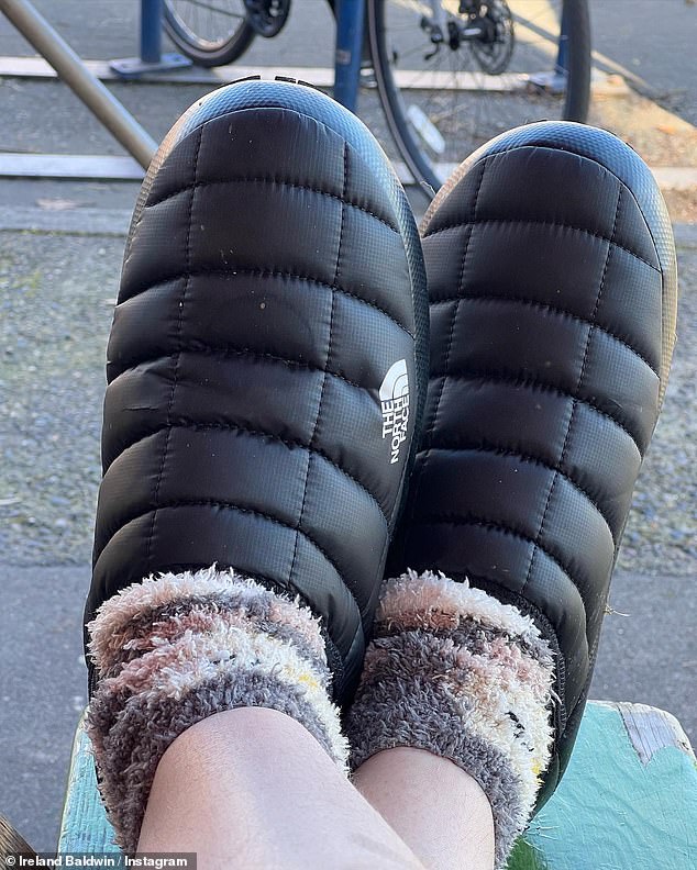 Staying cozy: Another snap saw her feet dressed in cozy black slippers from North Face, which she paired with furry socks