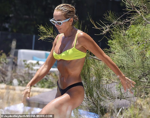 The mom-of-one flaunted her washboard abs in a bright yellow bikini top and thong bottom.