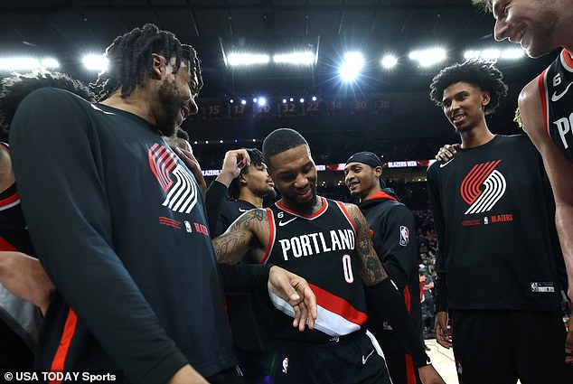 Lillard (0) huddles and celebrates with teammates after scoring 60 in a win against Utah