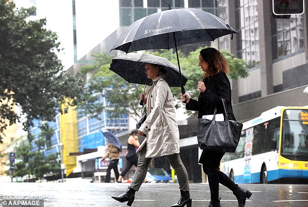 Heavy rain and thunderstorms are expected over NSW and Queensland this weekend, with Queensland could see heavier rain next week (pedestrians in Brisbane pictured)