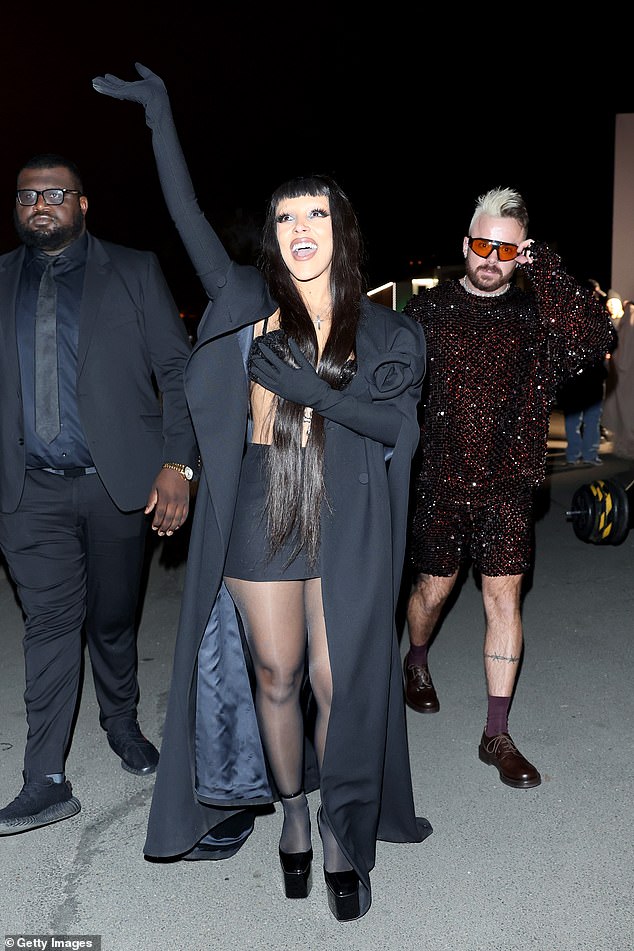 Having fun: The singer completed her look with a black miniskirt, tights and platform heels