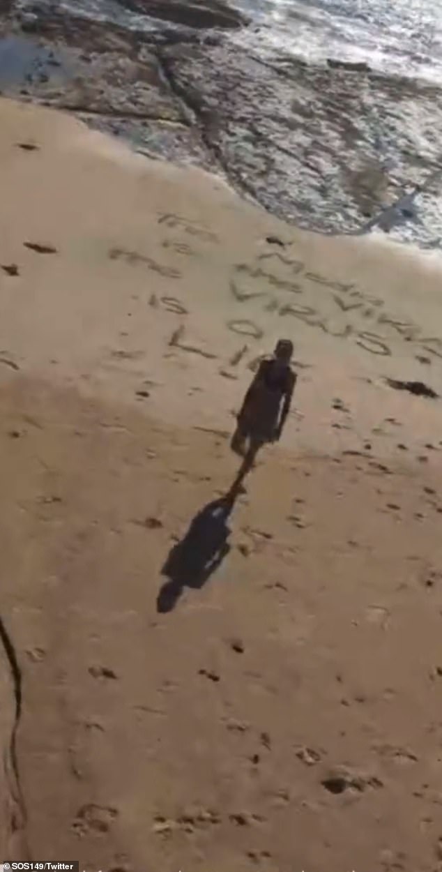 Guru goes to a lot of trouble to get a woman to help him write an anti-vaccination message in the sand on an Australian beach