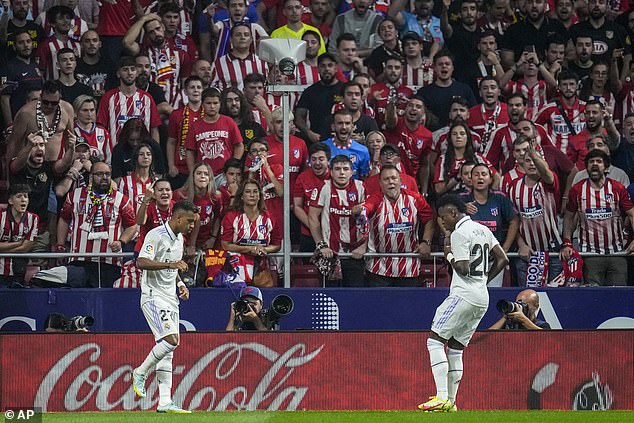 Vinicius celebrates Real's first goal scored by Rodrygo (left) during his team's 2-1 victory in September;  there is no suggestion that the Atlético fans pictured above racially abused Vinicius or were involved in hanging the effigy.