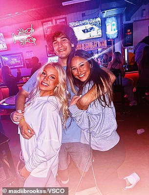 Madison Brooks (left) posing for a photo with friends at a bar