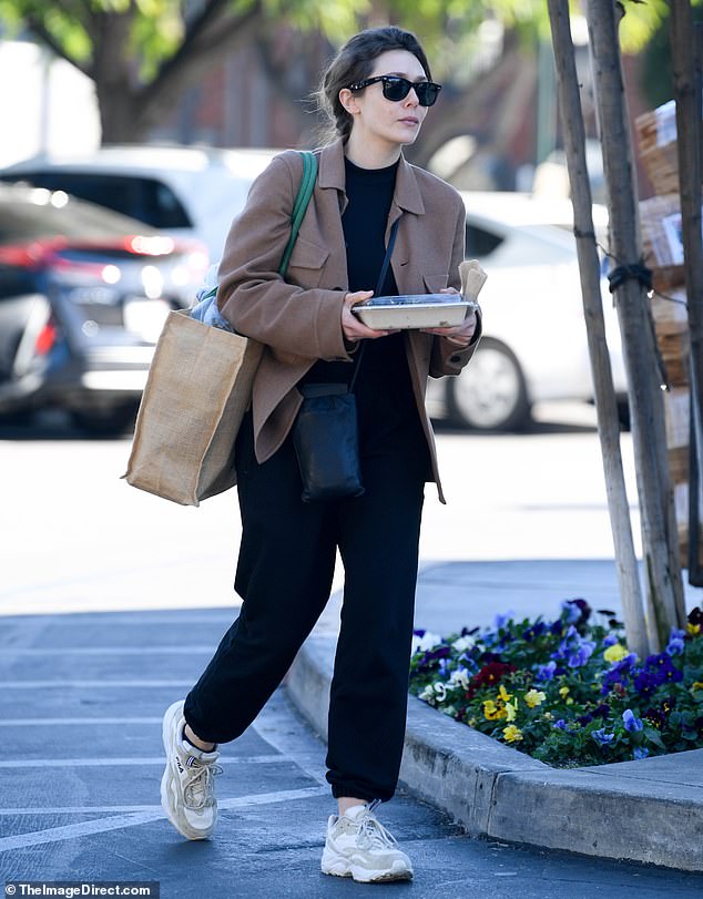 Stylish: The 33-year-old actress strutted the streets in a black shirt under a baggy brown blazer, black sweatpants and cream Fila sneakers