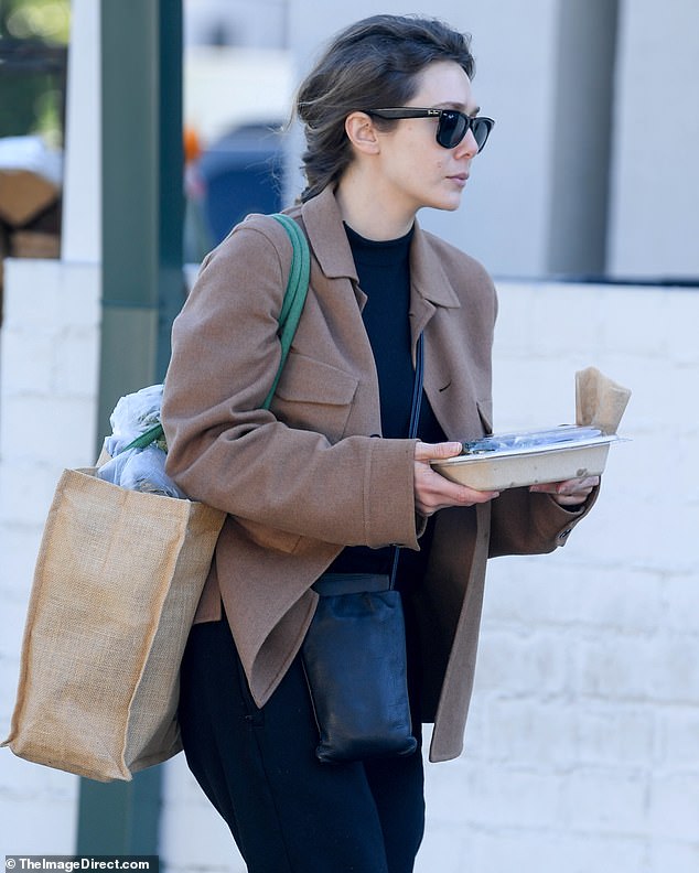 Pretty: The Marvel actress carried a large tweed bag with green straps, which was filled to the brim with things, and a small black crossbody bag