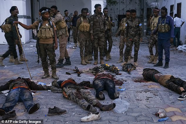 Police officers stand near the bodies of suspected Al-Shabaab militants who were killed after the siege of the Mogadishu Municipality headquarters in Mogadishu on January 22, 2023. The US announced an operation had eliminated the key ISIS agent Bilal al-Sudani in northern Somalia