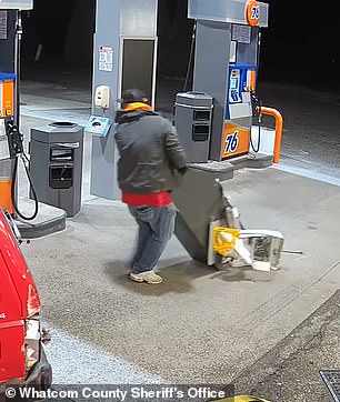 The man in the orange hoodie trying to get the cash back from the machine, even after his partner in crime broke it a bit, but he couldn't either.