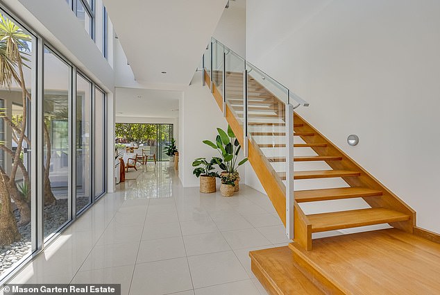 Downstairs, bi-fold doors open to a covered patio equipped with a BBQ fireplace.