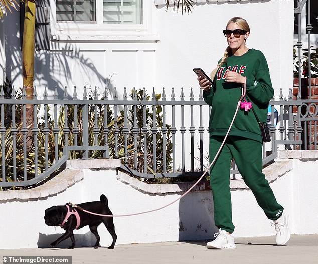 Keeping it consistent: El Moussa hid her midriff in a green crewneck sweater that she teamed with a set of matching sweatpants, both of which were contrasted with bright white sneakers.