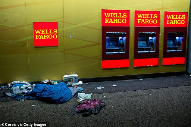 The belongings of a homeless person lie scattered inside the lobby of a Wells Fargo ATM in Los Angeles