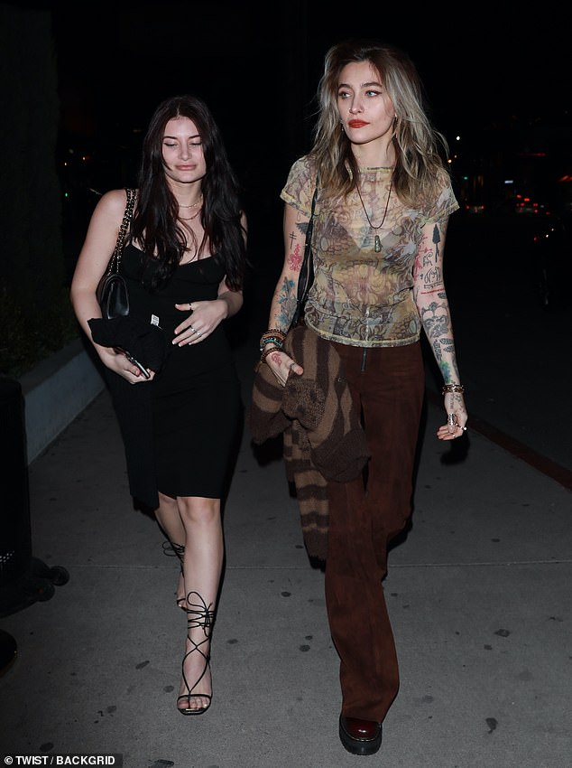 Night Out: She showed off a black bra through a mesh patterned tank top which she paired with a pair of brown zip-front wide leg pants as she walked inside.