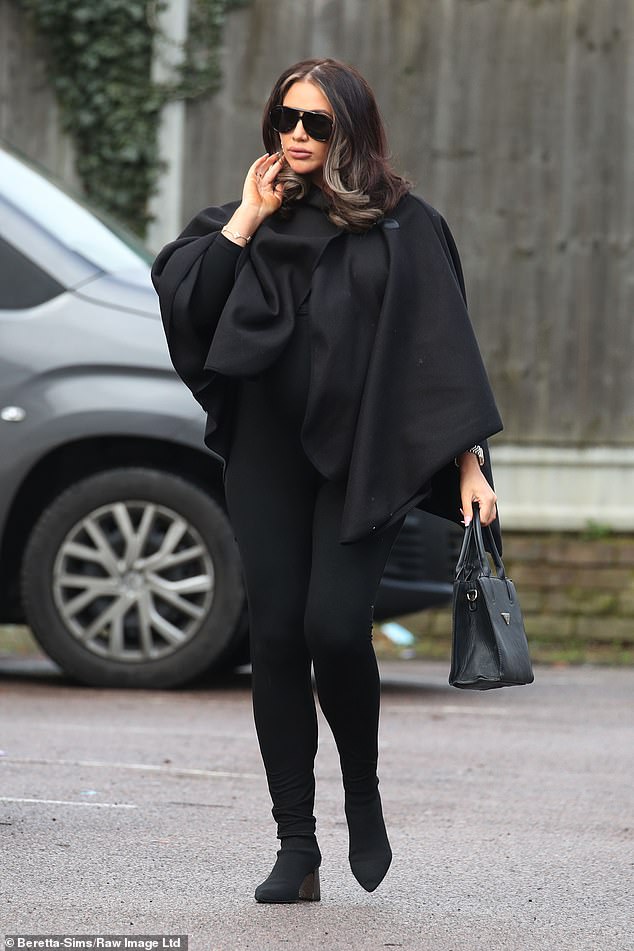 Elegant: Amy looked elegant that day, wearing a pair of black leggings with a cape-like dress and boots.