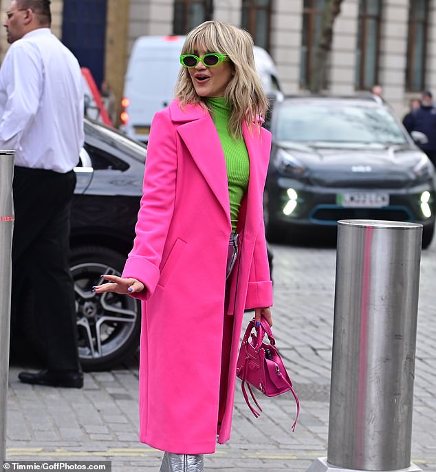 Good mood: Also in the same bold pink, Ashley carried her belongings in a matching tasseled bag.