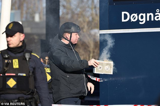 The activist is pictured burning another Koran outside a mosque in Noerrebro, Copenhagen, today