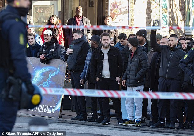 People react as far-right politician Paludan burns a Koran copy in front of a mosque in Copenhagen