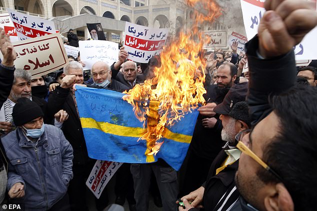 Iranians burn Sweden's flag during an anti-Sweden rally after the Friday prayer ceremony in Tehran today