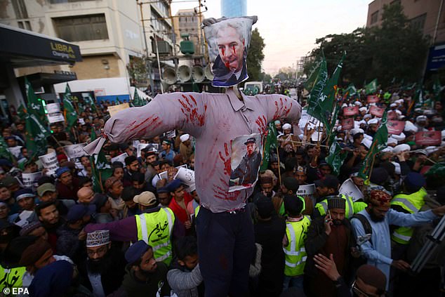 Protesters hold up a bloodstained effigy of Paludan during a protest in Karachi, Pakistan, today