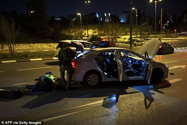 Israeli security forces search a car at the site of a reported attack in an East Jerusalem settler neighborhood.