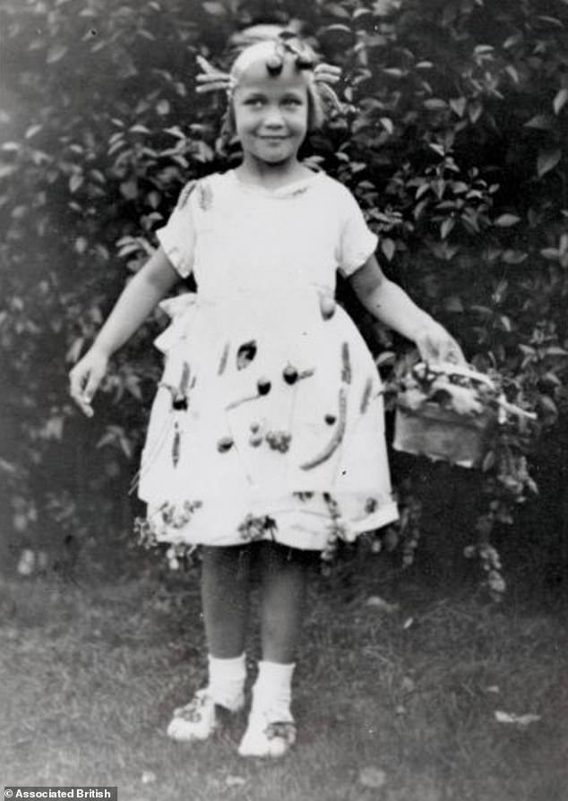 Five-year-old Sylvia shows off her Peace and Plenty dress decorated with fruit and vegetables for a costume contest in Eltham, south-east London, where she grew up.