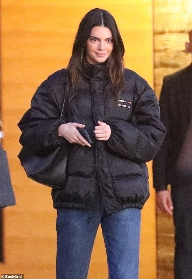 Cozy: The 27-year-old catwalk maven enjoyed the company of her friends in a cozy black puffer jacket