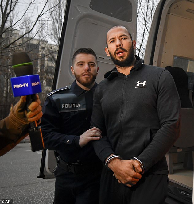 Andrew Tate (pictured handcuffed) and his brother were taken to DIICOT on Wednesday, where prosecutors examined electronic equipment seized during the investigation of their case, in Bucharest.