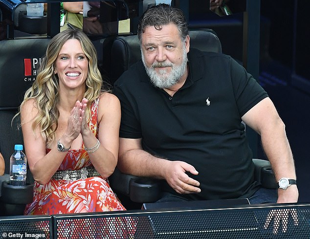 The couple applauded and chatted while watching the game.