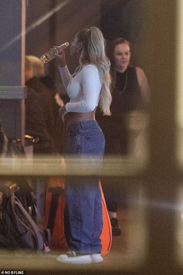 Outfit: The singer rocked a long-sleeved white crop top paired with a pair of dark blue jeans and black sneakers