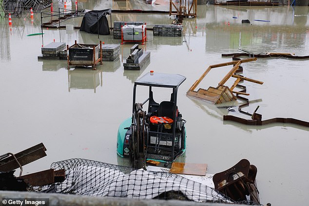 Widespread flooding in Auckland has claimed three lives and authorities warn the number could rise soon (a flooded workplace in Auckland pictured)