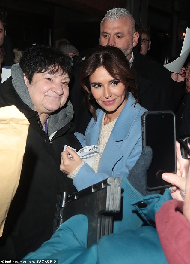 Meet and greet: Cheryl beamed and posed with a crowd of happy fans after her night at work