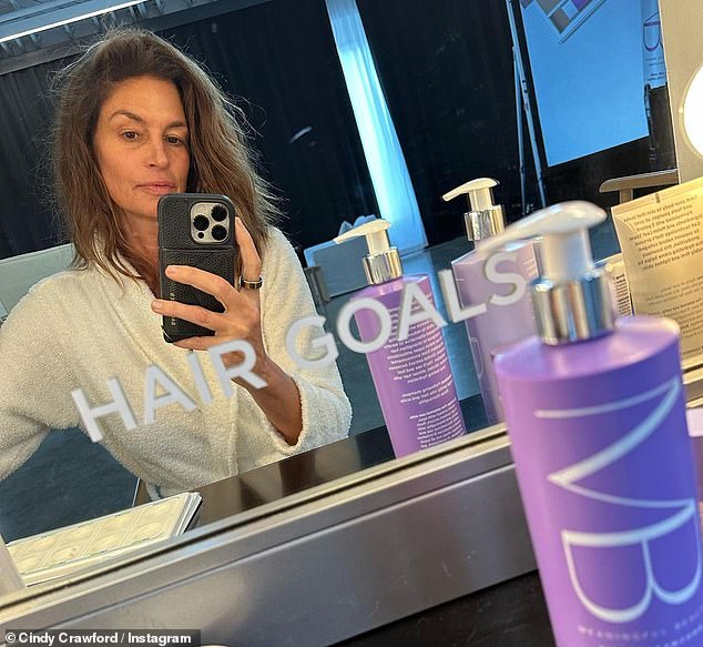 Hair goals: Crawford shared another makeup-free selfie when she posted a photo of herself next to her significant beauty shampoo.  'Hair goals', read the mirror