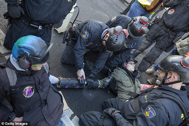 Officers began arresting protesters who refused to get off the road.  The activists were released after they chained each other.