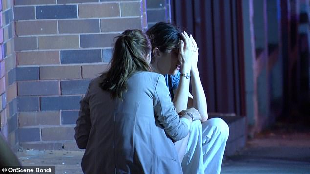 A distraught witness is shown being comforted by a woman at the scene in Bondi Junction.