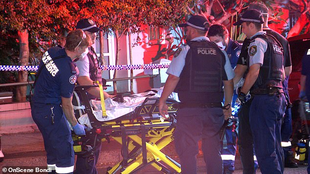 In the photo, the man receives treatment on a stretcher on the street in Bondi Junction.