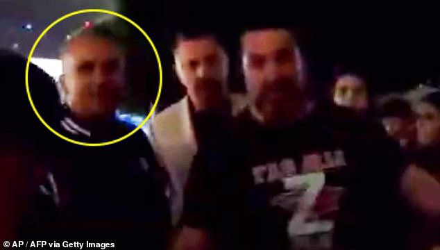 His concerns about fans sledding him were no doubt heightened when his father Srdjan (circled) was filmed with a man wearing a 'Z' T-shirt denoting his support for Vladimir Putin and behind a flag with the face of the Russian president (pictured)