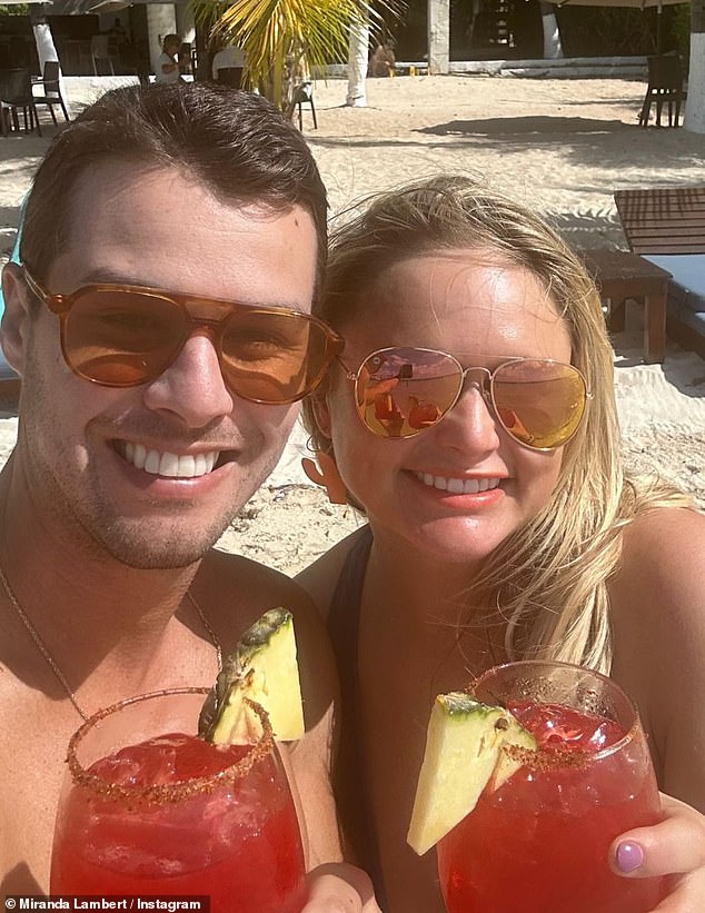 Having a drink: The country singer posted several snaps of her and her husband enjoying drinks and sunbathing on the beach during their tropical getaway