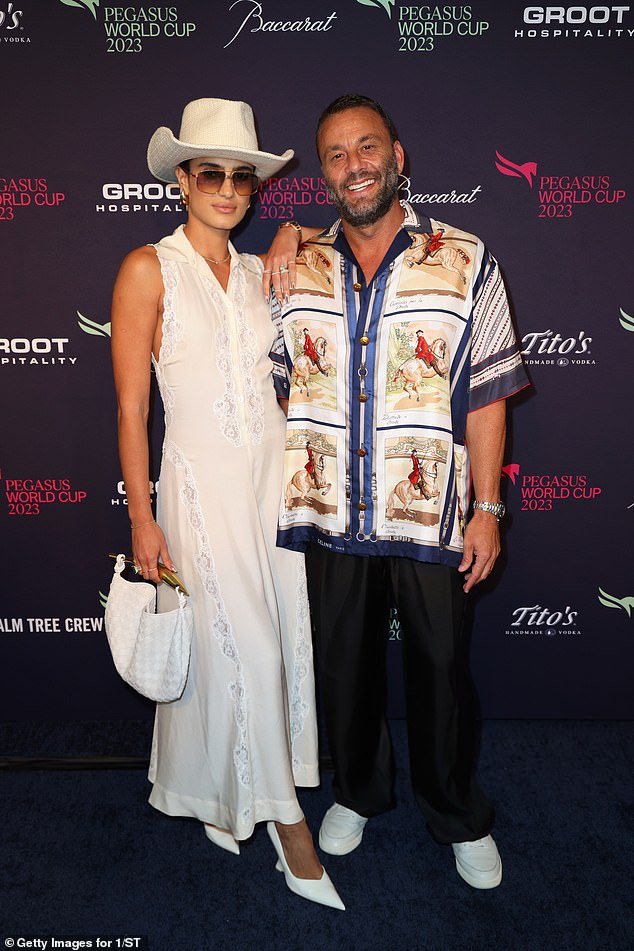 Cute couple: The businessman then posed for a photo with his wife Isabela Rangel, who wore a sleeveless white dress and matching heels