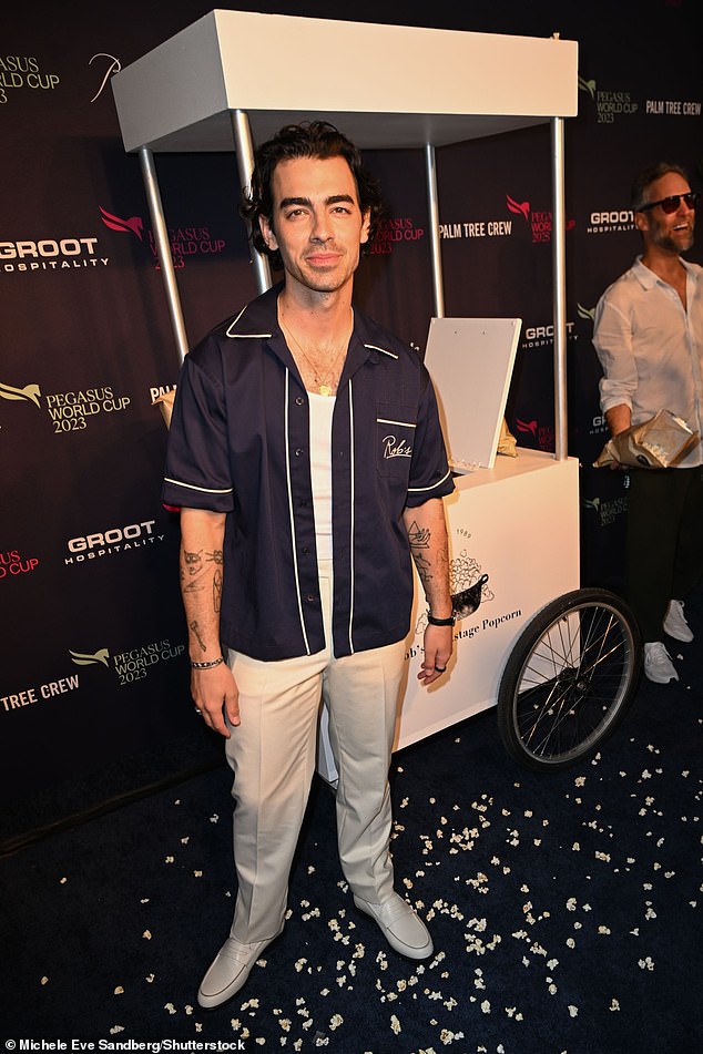 Comfortable clothing: Joe Jonas wore a navy blue button-down shirt over a white shirt and matching pants and shoes.