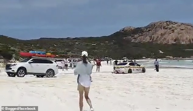 Beachgoers looked on, amused and puzzled, after the police car was stranded on the white sands of Wharton Beach in Cape Le Grande National Park, Esperance.