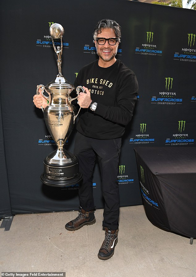 Sweater: Coco actor Jaime Camil, 49, donned a black sweater with gold lettering, black pants and oversized brown boots