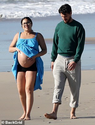 Banging: Periodically during her walk, she lifted up her dress to feel her baby bump.