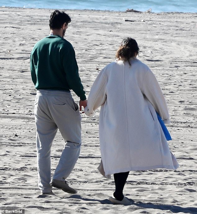 Sheltered: Rodríguez dons opaque tights and a cream coat during her walk