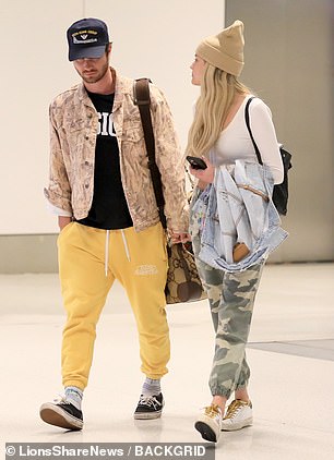 Arriving hand in hand: The couple held hands as they descended the escalator together.